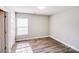 Bright bedroom with a window and wood-look flooring, view to closet at 1703 Southwind Dr, Charlotte, NC 28216