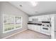 Bright kitchen features white cabinets and appliances with a view from the adjacent dining area at 1703 Southwind Dr, Charlotte, NC 28216