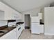 Functional kitchen featuring white cabinets, appliances, and contrasting countertops, with tile flooring at 1703 Southwind Dr, Charlotte, NC 28216