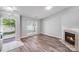 Bright living room with wood-look floors and a fireplace featuring an open view to the exterior at 1703 Southwind Dr, Charlotte, NC 28216