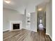 Bright, open-concept living room with fireplace, wood floors, and a glimpse into the adjacent kitchen and hallway at 1703 Southwind Dr, Charlotte, NC 28216