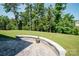 Beautiful backyard with a curved stone retaining wall featuring a flower pot and views of lush trees at 17718 Terryglass Ln, Charlotte, NC 28278