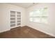 Bright bedroom featuring large windows, hardwood floors, and a modern closet system at 17718 Terryglass Ln, Charlotte, NC 28278