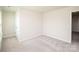 Bright bedroom with neutral carpet, one window, door, and neutral walls at 17718 Terryglass Ln, Charlotte, NC 28278