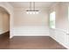 Bright dining room with hardwood floors, classic wainscoting, a modern light fixture, and large windows at 17718 Terryglass Ln, Charlotte, NC 28278