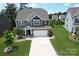 A charming two-story home featuring a well-manicured lawn, a two-car garage, and complementary landscaping at 17718 Terryglass Ln, Charlotte, NC 28278