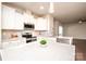 Bright kitchen featuring white cabinetry, a stainless steel oven, an island with white countertops, and modern backsplash at 17718 Terryglass Ln, Charlotte, NC 28278