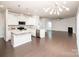 Bright, open-concept kitchen with white cabinets and countertops, stainless steel appliances, and dark hardwood flooring at 17718 Terryglass Ln, Charlotte, NC 28278