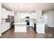 An open concept kitchen featuring modern stainless steel appliances, a stylish island, and bright white cabinetry at 17718 Terryglass Ln, Charlotte, NC 28278