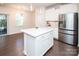 Well-lit kitchen showcasing white cabinetry, a stainless steel fridge, and an island featuring a white countertop at 17718 Terryglass Ln, Charlotte, NC 28278