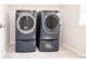 Contemporary laundry room featuring a washer and dryer with pedestals and ample overhead storage space at 17718 Terryglass Ln, Charlotte, NC 28278