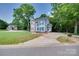 Two-story home with blue shutters, lush landscaping, and a wide driveway leading to the street at 2014 Steeplechase Dr, Rock Hill, SC 29732