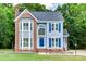 Charming two-story home with blue shutters and brick accents, set amidst lush green trees at 2014 Steeplechase Dr, Rock Hill, SC 29732