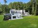 Back exterior of two-story home featuring patio and mature trees surrounding the property at 202 Walden Ln, Weddington, NC 28104