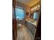 Bathroom with long vanity and cabinets, decorative wallpaper, and a window at 204 Brentwood Dr, Maiden, NC 28650