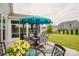 Cozy outdoor patio with comfortable seating, a shade umbrella, and a view of the yard at 2296 Idol Rock Dr, Indian Land, SC 29707