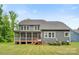 Rear exterior view showing a screened-in porch, multiple windows, and manicured lawn at 2525 Surveyor General Dr, Waxhaw, NC 28173