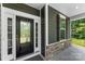 Inviting front entrance featuring a glass-paneled door, stone accents, and a covered porch at 2525 Surveyor General Dr, Waxhaw, NC 28173
