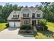 Charming two-story home featuring stone and gray siding, a well-manicured lawn, and a two-car garage at 2525 Surveyor General Dr, Waxhaw, NC 28173