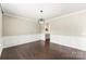 Elegant living area with dark hardwood floors, white wainscoting, and a view to the butler's pantry at 2525 Surveyor General Dr, Waxhaw, NC 28173