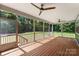 A beautiful screened-in back patio with wood floors and two ceiling fans overlooking a wooded backyard at 2525 Surveyor General Dr, Waxhaw, NC 28173