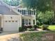 Charming home boasts a manicured lawn, attached garage, and inviting covered porch, complemented by lush landscaping at 2545 Chasewater Dr, Fort Mill, SC 29707