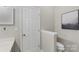 Bathroom with white toilet and door, featuring gray walls, and decorative mountain art at 3212 Ashwell Oaks Ln, Matthews, NC 28105