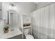 A neutral bathroom contains a shower with striped curtain and storage above the toilet at 3212 Ashwell Oaks Ln, Matthews, NC 28105