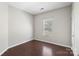 Secondary bedroom featuring hardwood floors, neutral paint, and a window with natural light at 3212 Ashwell Oaks Ln, Matthews, NC 28105