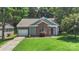 Home with a manicured lawn, brick accents, attached garage, and mature trees at 3212 Ashwell Oaks Ln, Matthews, NC 28105
