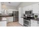 Well-lit kitchen featuring stainless steel appliances, white cabinets, and tile flooring at 3212 Ashwell Oaks Ln, Matthews, NC 28105