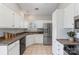 Bright kitchen featuring stainless steel refrigerator, white cabinets, and tile flooring at 3212 Ashwell Oaks Ln, Matthews, NC 28105