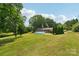 Expansive backyard featuring a round above ground pool with lush greenery and mature trees at 327 Johnson Dairy Rd, Mooresville, NC 28115