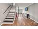 View of a finished basement with hardwood floors, painted stairs, and a black safety gate at 327 Johnson Dairy Rd, Mooresville, NC 28115