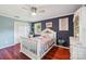 Charming bedroom with hardwood floors, white trim, blue walls and decor and a comfortable bed at 327 Johnson Dairy Rd, Mooresville, NC 28115