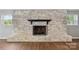 Close up of a beautiful whitewashed brick fireplace with wood mantel and screen at 327 Johnson Dairy Rd, Mooresville, NC 28115