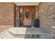 Close-up of the front door with decorative glass, flanked by planters, adding a welcoming touch at 327 Johnson Dairy Rd, Mooresville, NC 28115