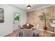 Cozy dining room featuring brick accent wall, modern lighting, and a charming dining set for intimate meals at 3427 Wonderland Dr, Matthews, NC 28104