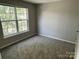 A bright bedroom with large window illuminating the plush carpeting and neutral walls at 3617 Betterton Ln, Charlotte, NC 28269
