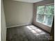 A cozy bedroom features natural light from a large window and plush carpeting at 3617 Betterton Ln, Charlotte, NC 28269