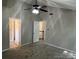 Spacious bedroom with fan, neutral colors, carpet, and doorways to the bathroom and hallway at 3617 Betterton Ln, Charlotte, NC 28269