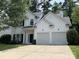 Charming two-story home featuring a two-car garage, lush lawn, and a classic white facade at 3617 Betterton Ln, Charlotte, NC 28269