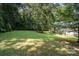 Spacious green backyard with trees, offering shade and privacy, and features a glimpse of the house at 394 Link Dr, Iron Station, NC 28080