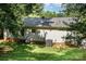 Partially shaded backyard with well-maintained lawn and features the home's exterior and mature trees at 394 Link Dr, Iron Station, NC 28080