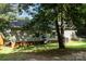 Shaded backyard featuring a shed, lush grass, and the home's exterior with mature trees at 394 Link Dr, Iron Station, NC 28080