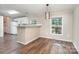 Eat-in kitchen features white cabinets, modern lighting, and sleek hardwood floors at 394 Link Dr, Iron Station, NC 28080