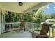 Relaxing porch view with chairs, serene green backdrop, and a glimpse of the neighboring home at 394 Link Dr, Iron Station, NC 28080