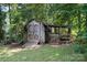 Rustic wooden shed with a small porch set among trees in the backyard at 394 Link Dr, Iron Station, NC 28080