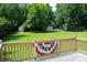 Expansive green backyard featuring outbuildings and a deck with patriotic bunting, perfect for outdoor enjoyment at 412 E Taylor St, Landis, NC 28088