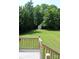 View of a lush green backyard and an outbuilding, captured from the wooden deck with stairs leading down at 412 E Taylor St, Landis, NC 28088